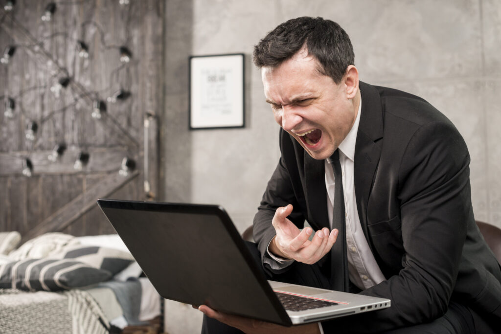 Mastering Document Consistency: The Pros and Cons of House Styles. A blog post by OutSec, the UK's leading online transcription company. Image shows a man shouting at a computer when he is struggling to format a document to a house style